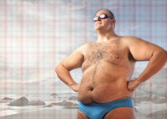 толстый мужчина в очках на пляже